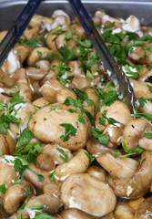 Sauteed mushrooms with garlic and parsley served during catering event.
