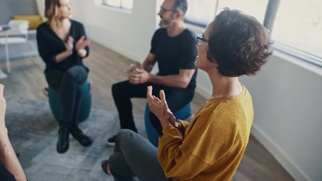 Coach talking with the team during a training session in the office. Corporate professionals engaged in personal development training program.
