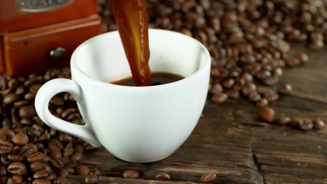 Super slow motion of pouring coffee into cup in detail. Filmed on high speed cinema camera, 1000fps