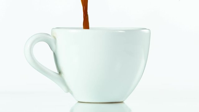 Super slow motion of pouring coffee into cup, isolated on white background. Filmed on high speed cinema camera, 1000fps