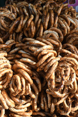 German pretzels stack one over each other, group of thin dry pretzels on rope