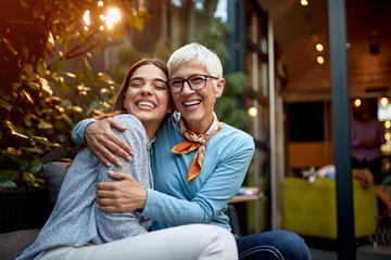 Fotobehang portrait of a senior mother and adult daughter, hugging, smiling. Love, affection, happiness concept © luckybusiness