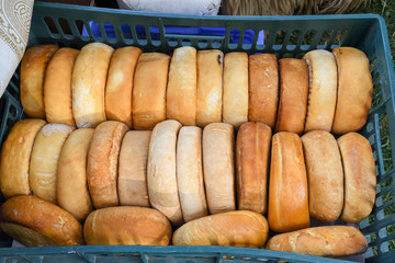 A variety of wheels of cheese seasoned with herbs for sale at the deli counter in the supermarket.