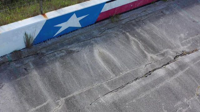 Cracking pavement, rusting fence, and empty racetrack press box, College Station, Texas, USA