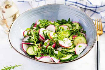 Vegetarian vegetable salad of radish, cucumbers, arugula and green onions. Healthy  vegan food.