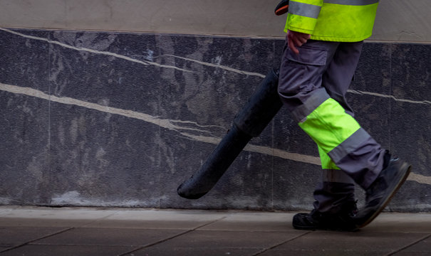 Cleseup Worker Clean Public Concrete Floor With Vacuum Cleaner. Worker Wear Uniform Use Leaf Blower Clean Sidewalk In The City. Janitor Blowing Dust On Sidewalk. Cleaning City For Good Hygiene Concept