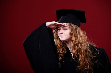 Female student in academic gown in red background