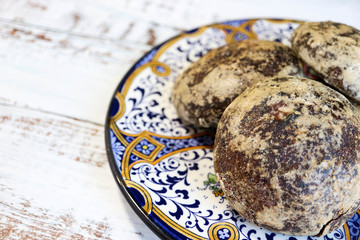bunch of round gingerbread on the beautiful ornamental plate on wooden table