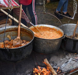 Very large cauldron cooking food during campfire. Cooking in a pot on the fire. Camping concept