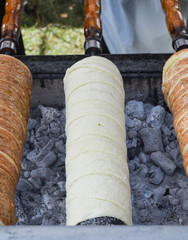 Kurtos kalacs or chimney cakes, preparing on charcoal grill, street food traditional Hungarian
