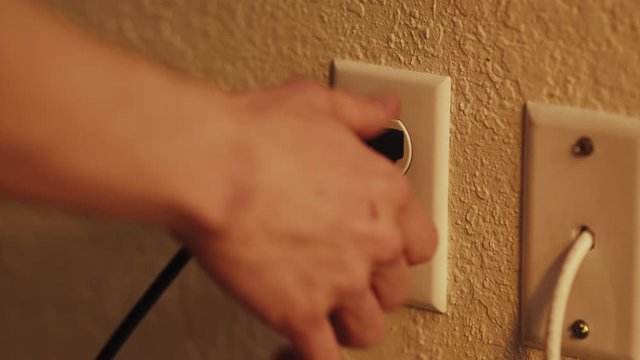 Male hand plugs in, unplugs, fails to plug in, then plugs in three-pong cord into outlet.

Tripod. Fixed Focus. Close-Up. 23.976 FPS. Action.