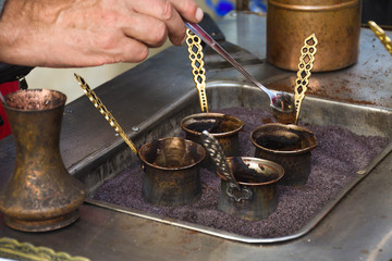 Fototapeta na wymiar Turkish coffee reparation during street food festival, traditional specialty drink served