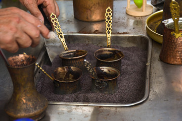 Turkish coffee reparation during street food festival, traditional specialty drink served