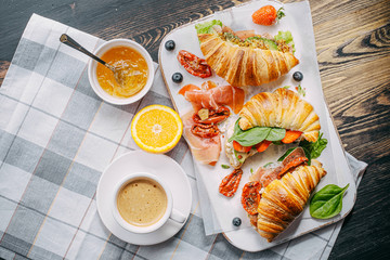 The concept of a hearty and tasty breakfast of fresh classic croissants with a variety of toppings...
