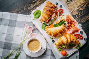 The concept of a hearty and tasty breakfast of fresh classic croissants with a variety of toppings...