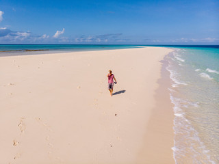 Traveller on Zanzibar. Empty beach at Snow-white sand bank of Nakupenda Island. Appearing just a few hours in a day. Aerial drone shot