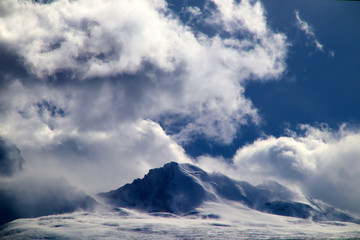 Plateau, Hochspannungsmast, blauer Himmel und weiße Wolken, Eissee und ferner Shishapangma-Gipfel