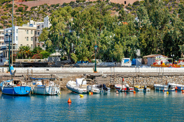 The picturesque promenade of Loutraki Bay, Greece, where old fishing schooners, boats and boats moor in the clear waters of the Ionian Sea.