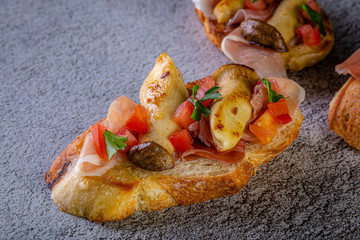 Bruschetta with proscuitto ham, tomatoes and King oyster mushroom. Iitalian style food