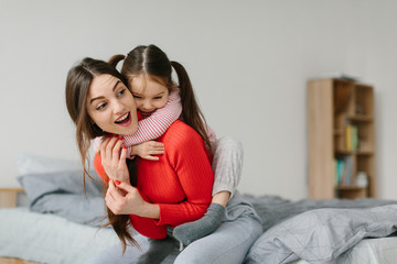 Happy loving family. Mother and her daughter child girl playing and hugging.