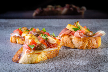 Bruschetta with proscuitto ham, tomatoes and King oyster mushroom. Iitalian style food