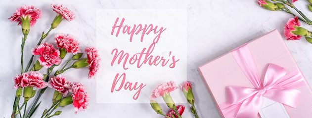 Fototapeta na wymiar Happy Mother's Day background design concept with greeting words, beautiful pink, red carnation flower bouquet on marble table, top view, flat lay, copy space.
