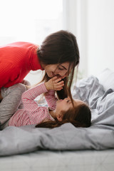 Happy loving family. Mother and her daughter child girl playing and hugging.