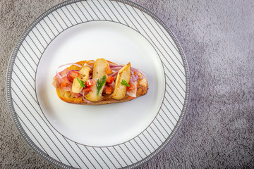 Bruschetta with proscuitto ham, tomatoes and King oyster mushroom. Iitalian style food