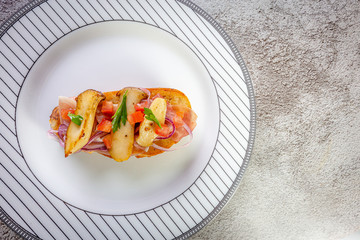 Bruschetta with proscuitto ham, tomatoes and King oyster mushroom. Iitalian style food