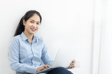 Happy Asian woman using laptop on the floor at home, work from home concept.
