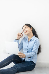 Happy Asian woman using laptop on the floor at home, work from home concept.