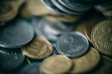 A macro shot of a large number of Ukrainian coins piled in chaos. Very shallow depth of field.