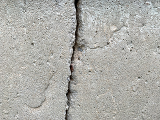 Close up photo of a crack in a concrete foundation. Structural repair and construction.