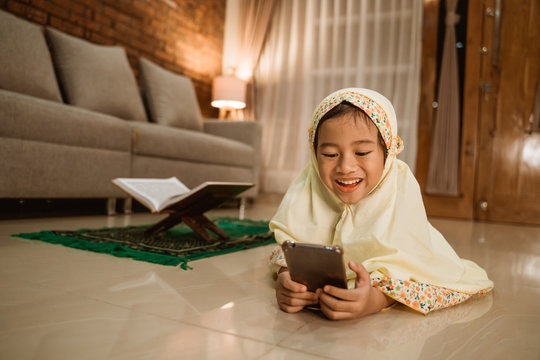 Muslim Kid Using Mobile Phone After Praying At Home