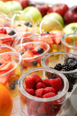 bicchieri di plastica con frutta di un tipo o assortita quale fragole uva, more, anguria ecc