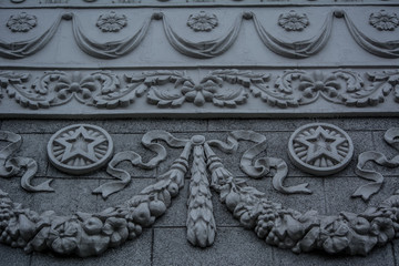 wall decorated with stars. stucco molding on a gray building. stucco molding from wreaths and stars. soviet style