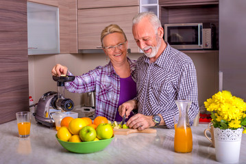 Happy senior couple preparing healthy food together in the kitchen