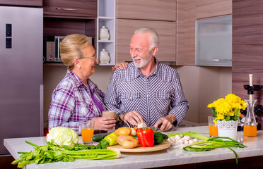 Senior couple enjoying while preparing lunch together in the kitchen
