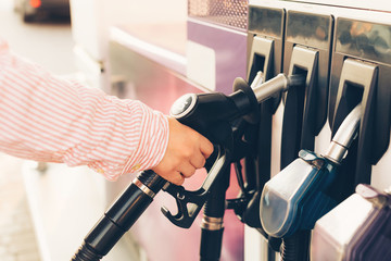 Close-up of a man’s hand taking a petrol pump at gas station. Auto service
