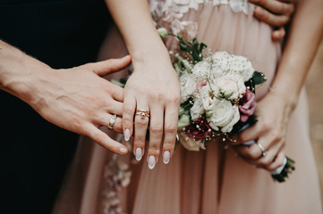 hands of bride and groom
rings 
bridal bouquet