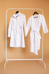 Medical gowns are on a rack hanger.