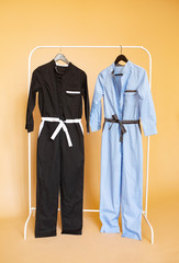 Overalls for medical workers are on rack hanger on orange background.