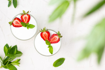 Healthy strawberry yogurt with in glasses with fresh berries over white table. Top view with copy space