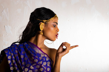 Indian girl wearing a traditional blue saree and gold jewellry