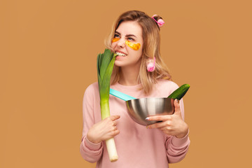 Girl bites leek aggressively and looks up.