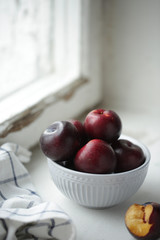 plum in a plate near the window

