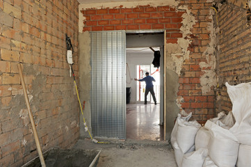 Complete house renovation. Placing a metallic cassette for a new sliding door in the kitchen. 