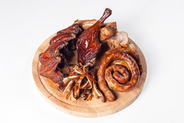
Appetizing set of smoked meat: spiral fried sausage, chicken leg, buffalo chicken wings, sliced ​​smoked meat. On a wooden tray. On a white background in isolation.