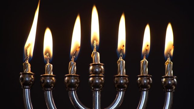 Close up of Menorah With All Candles Burning on Black Background. Hanukkah
