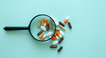 The pills under scrutiny.medicine, drug, vitamin, pharmacy,magnifier,concept